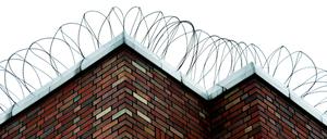 Stacheldraht auf rotem Backstein: Die Jugendstrafanstalt Berlin Plötzensee, Pforte 2, am Friedricht-Olbricht-Damm 40 in Berlin-Charlottenburg.