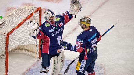 Berlins Goalie Mathias Niederberger und Mark Olver jubeln nach ihrem 5:0 Sieg gegen die Kölner Haie.
