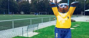 Bärenfigur in gelb-blauen Vereinsfarbem am Sportplatz der Sportfreunde in Berlin-Kladow.