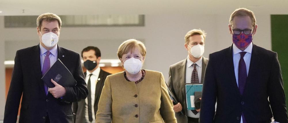 Bundeskanzlerin Angela Merkel (CDU) neben Markus Söder (CSU, l), Ministerpräsident von Bayern und CSU-Vorsitzender, sowie Michael Müller (SPD, r), Regierender Bürgermeister von Berlin.