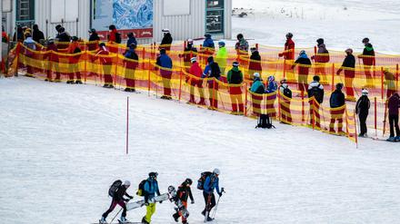Skifahrer stehen an einem Skilift in Österreich in einer Schlange.