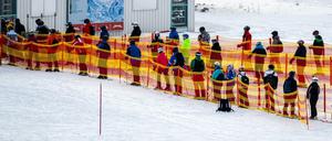 Skifahrer stehen an einem Skilift in Österreich in einer Schlange.