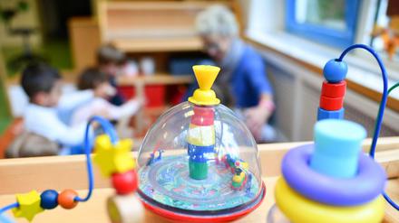 Eine Erzieherin spielt mit Kindern in einer Kita.