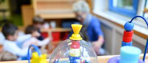 Eine Erzieherin spielt mit Kindern in einer Kita.