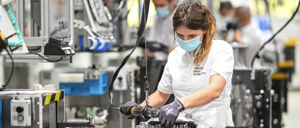 Eine Monteurin arbeitet in einem Werk des Automobilzulieferers ZF Friedrichshafen an ein Getriebe für Lastwagen.