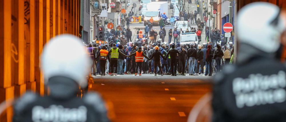 Polizeibeamte stehen vor dem Eingang eines Tunnels. Auf der anderen Seite Demonstranten.