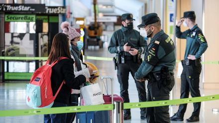 Ratlose Reisende sprechen am Flughafen von Ibiza mit einem Beamten.