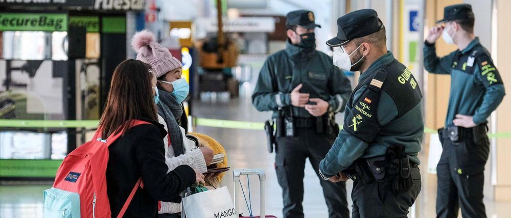 Ratlose Reisende sprechen am Flughafen von Ibiza mit einem Beamten.