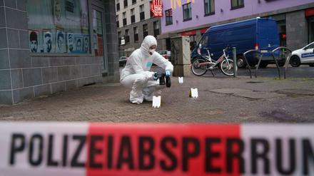 Beamte der Spurensicherung sichern Blutspuren auf dem Gehweg in der Niddastraße.
