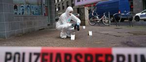 Beamte der Spurensicherung sichern Blutspuren auf dem Gehweg in der Niddastraße.