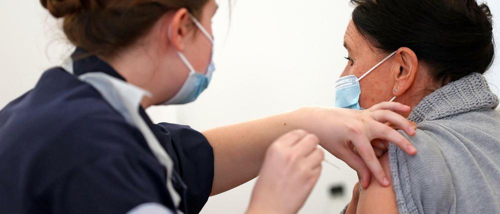 Eine Frau erhält in England dem Impfstoff von Astrazeneca.