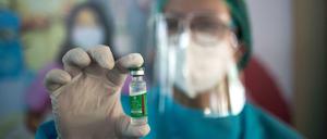Eine medizinische Mitarbeiterin hält eine Dose des Astrazeneca-Impfstoffes hoch.