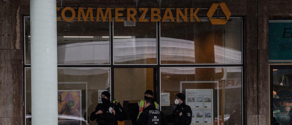 Polizisten stehen am Eingang einer Bankfiliale an der Blissestraße in Wilmersdorf.