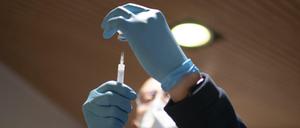 Ein Mitarbeiter bereitet eine Corona-Impfung vor (Symbolbild).