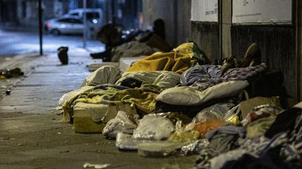 Obdachlose Menschen liegen unter einer Brücke am Zoo.