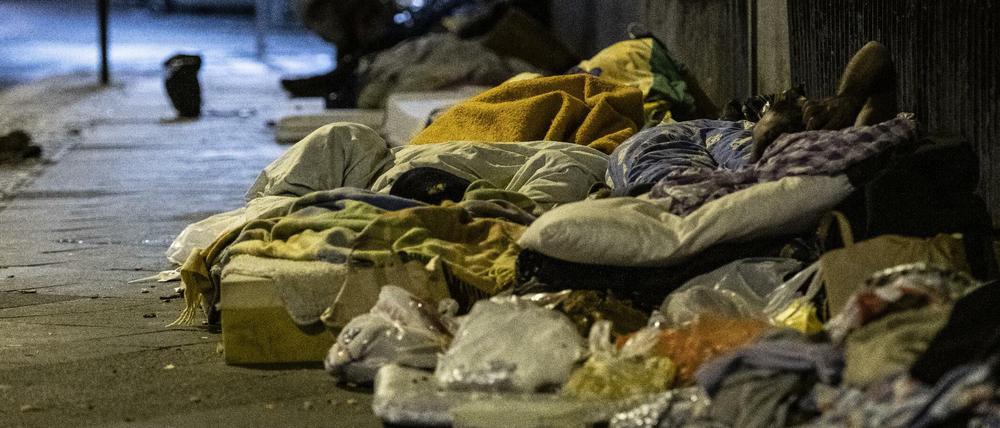 Obdachlose Menschen liegen unter einer Brücke am Zoo.