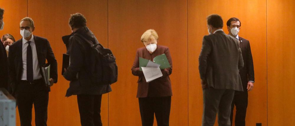 Angela Merkel (M) und Michael Müller (l) kommen zur Pressekonferenz nach dem Corona-Gipfel an.