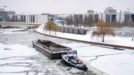 Ein Schubverband bahnt sich bei frostigen Temperaturen den Weg durch das Eis auf der Spree im Berliner Regierungsviertel.