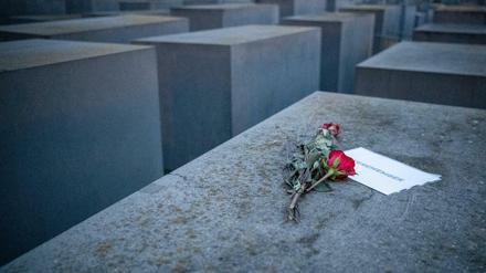 Rosen liegen mit einem Zettel, mit der Aufschrift "#weremember" am Holocaust-Mahnmal.