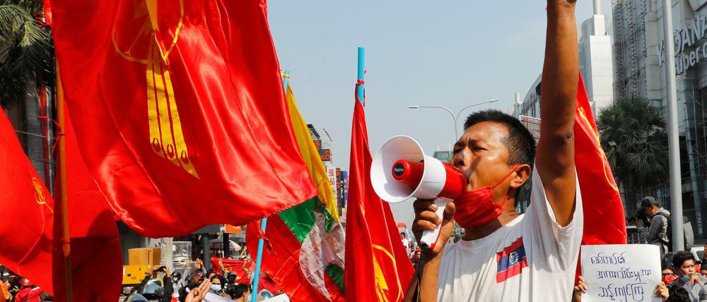 Ein Mann spricht bei einer Demonstration in Mandalay in ein Megafon.