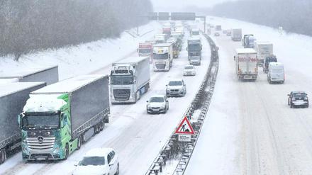 Autos und LKWs stehen auf der Autobahn A3 in Richtung Oberhausen durch Schneefall im Stau.