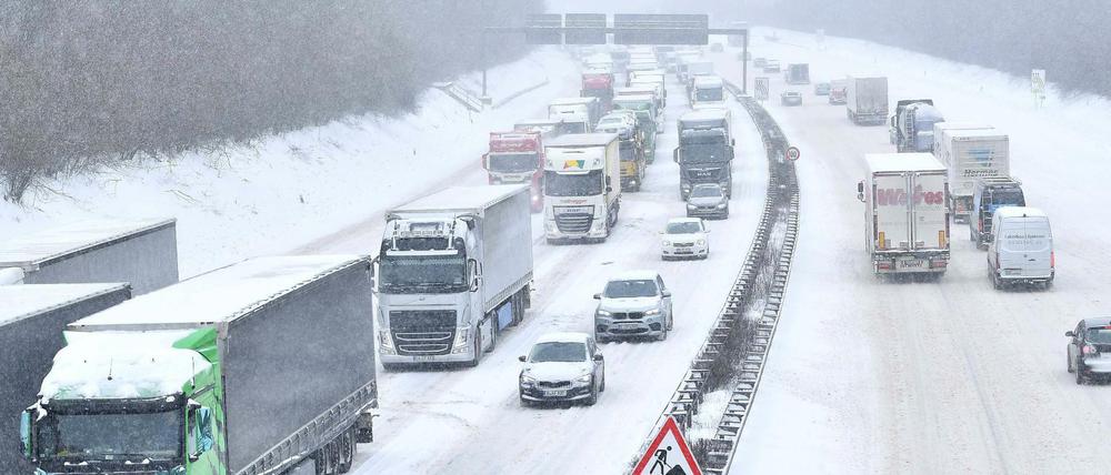 Autos und LKWs stehen auf der Autobahn A3 in Richtung Oberhausen durch Schneefall im Stau.