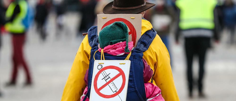 Eine Teilnehmerin einer Protestkundgebung der Initiative "Querdenken" trägt ein Schild gegen Impfungen.