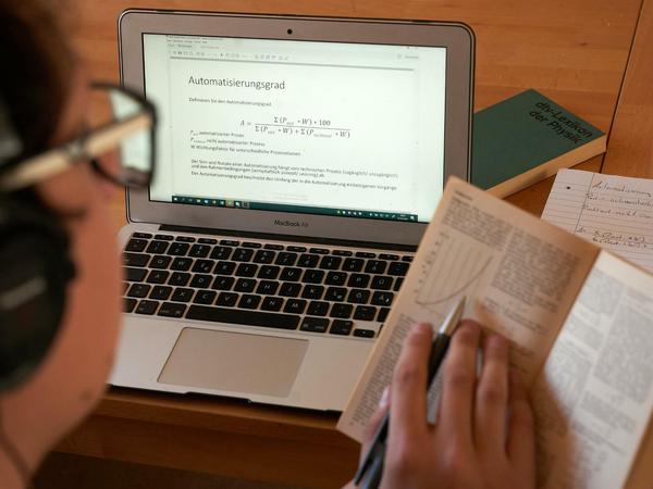 Ein Student bearbeitet ein Arbeitsblatt am Laptop.