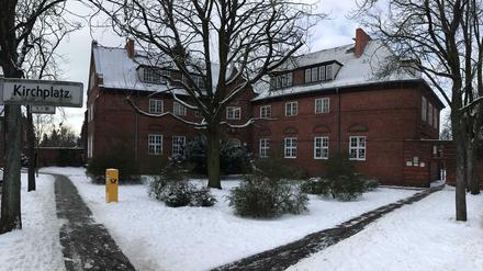 Staaken, Februar 2021. "Kirchplatz". Links die Schule, durchs Tor geht es zur Kirche.