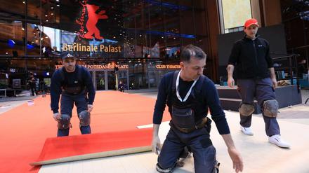 Immer auf dem Teppich bleiben. Arbeiter verlegen den Roten Teppich vor dem Berlinale Palast.