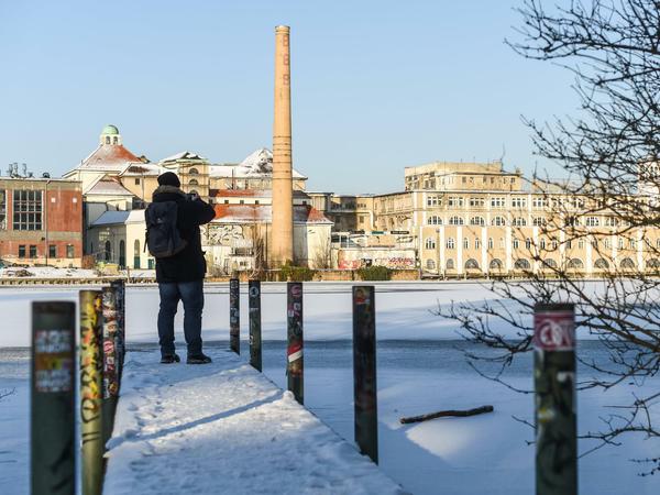Ein Steg an der eisigen Spree mit Blick auf die alte Brauerei Berliner Bürgerbräu in Friedrichshagen.