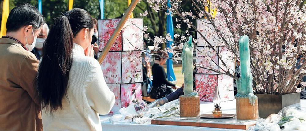 Stilles Gebet. Zahlreiche Menschen versammelten sich am 11. März 2020 in einer Gedenkstätte im Hibiya Park von Tokio.