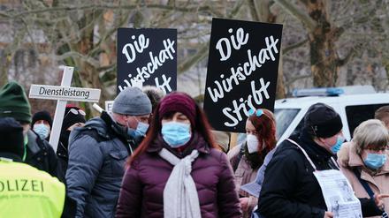 Menschen demonstrieren gegen die Corona-Politik der Regierung und weisen auf die schwierige Situation der Wirtschaft hin.