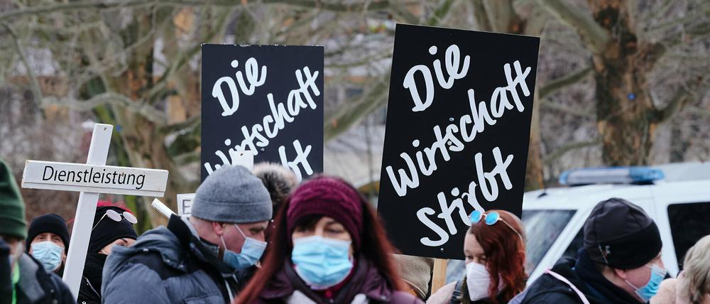 Menschen demonstrieren gegen die Corona-Politik der Regierung und weisen auf die schwierige Situation der Wirtschaft hin.