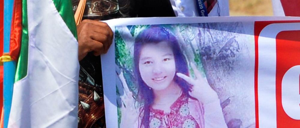Ein Demonstrant trägt ein Plakat mit einem Foto von Mya Thwate Thwate Khaing.