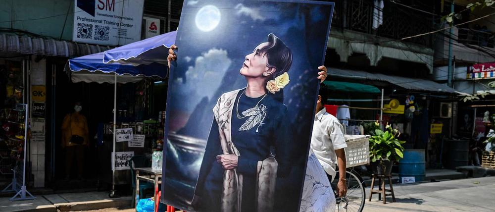 Ein Protestierender mit einem großen Plakat, das die bisherige De-facto-Regierungschefin Aung San Suu Kyi zeigt. 