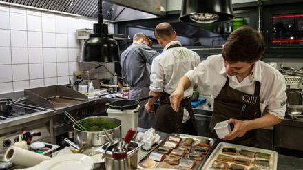 Die Küche des - derzeit wegen Corona geschlossenen - Restaurants QIU im Mandala-Hotel am Potsdamer Platz in Berlin (im Oktober 2019): Küchenchef Moritz Ehrlich bereitet Saibling zu. Hilfskräften kann das Hotel nach eigenen Angaben keine 12,50 Euro die Stunde zahlen.