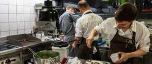Die Küche des - derzeit wegen Corona geschlossenen - Restaurants QIU im Mandala-Hotel am Potsdamer Platz in Berlin (im Oktober 2019): Küchenchef Moritz Ehrlich bereitet Saibling zu. Hilfskräften kann das Hotel nach eigenen Angaben keine 12,50 Euro die Stunde zahlen.
