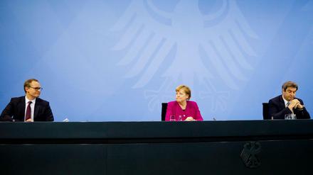 Angela Merkel (M, CDU), Markus Söder (r, CSU) und Michael Müller (SPD) nehmen nach einem Treffen im Kanzleramt an einer Pressekonferenz teil.