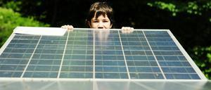 Ein Schüler in Berlin-Reinickendorf schaut über den Rand einer Solarzelle.