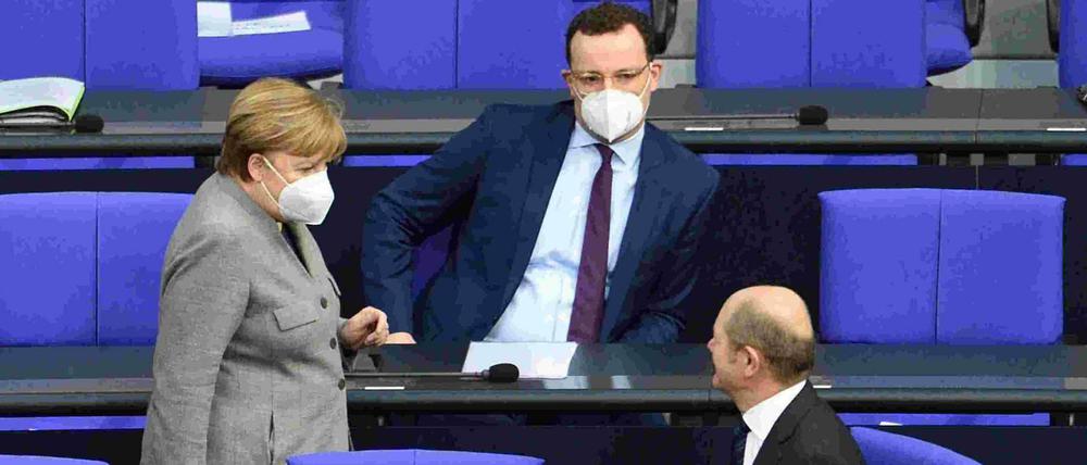 Angela Merkel, Jens Spahn (beide CDU) und Olaf Scholz (SPD) im Bundestag.