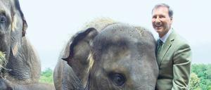 Zoo- und Tierparkdirektor Andreas Knieriem steht bei einem Presserundgang im August 2016 im Tierpark in Berlin-Friedrichsfelde neben einem Elefanten.