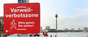 Düsseldorf: Verbotsschilder "Verweilverbotszone - Bitte gehen Sie weiter" und "Freitag 15 bis 1 Uhr - Samstag/Sonntag 10-1 Uhr" an der Rheinpromenade.