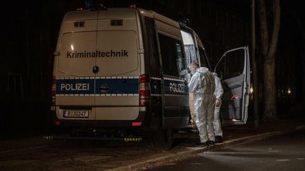 Kriminaltechniker stehen am frühen Sonntagmorgen an ihrem Einsatzfahrzeug an einem Wohnhaus im Berliner Bezirk Reinickendorf. 