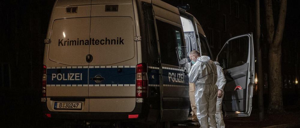 Kriminaltechniker stehen am frühen Sonntagmorgen an ihrem Einsatzfahrzeug an einem Wohnhaus im Berliner Bezirk Reinickendorf. 