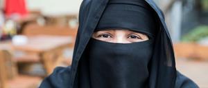 Eine Touristin aus Riad sitzt in einem Restaurant in der Schweiz
