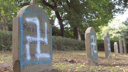 Grabsteine auf einem jüdischen Friedhof sind mit Hakenkreuzsymbolen beschmiert.