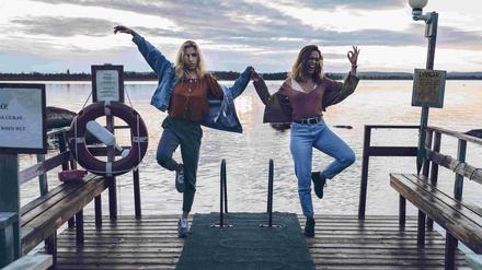 Zwei junge Finninnen tanzen an einem See.