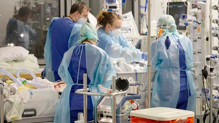 Ärtinnnen, Ärzte und Pflegende arbeiten auf der Corona-Intensivstation der Charité am Bett einer jungen Patientin. Szene aus der RBB-Dokumentation "Die Story im Ersten: Auf der Covid-Intensivstation der Charité - Kampf um jeden Atemzug". 