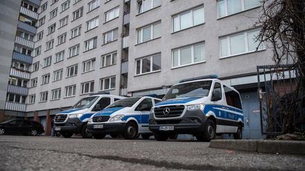 Einsatzfahrzeuge der Polizei bei der Razzia in Berlin-Lichtenberg vor einem Wohnhaus.